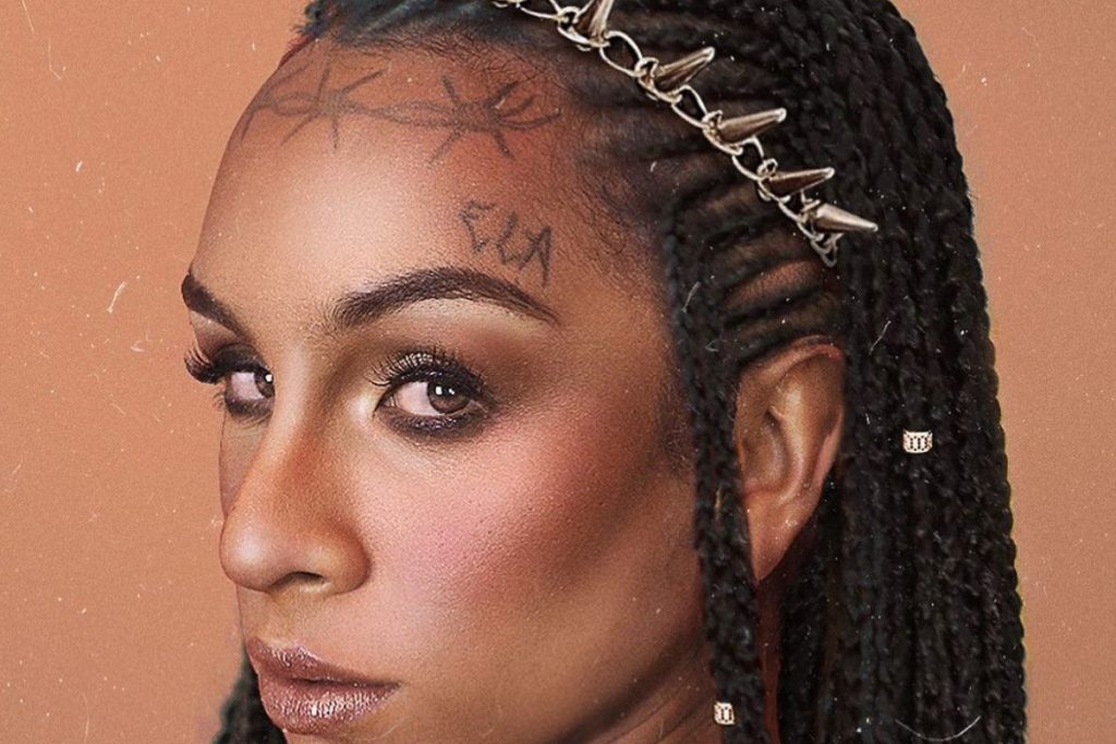 Foto mostra Linn da Quebrada com o pronome ELA tatuado acima das sobrancelhas