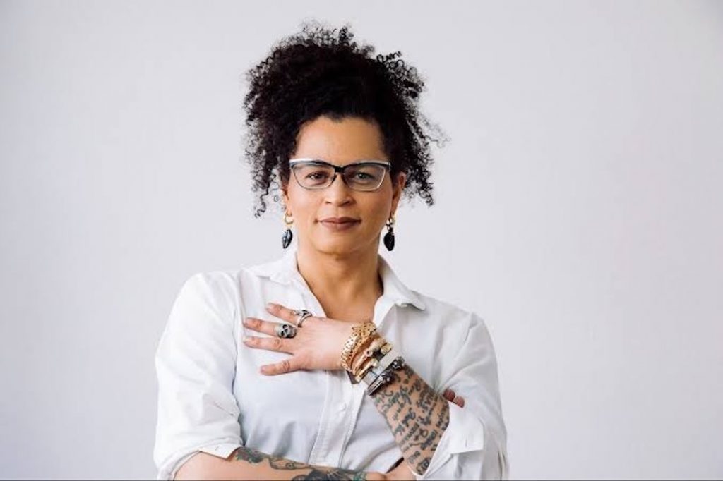 Mulher negra transgênera veste camisa branca