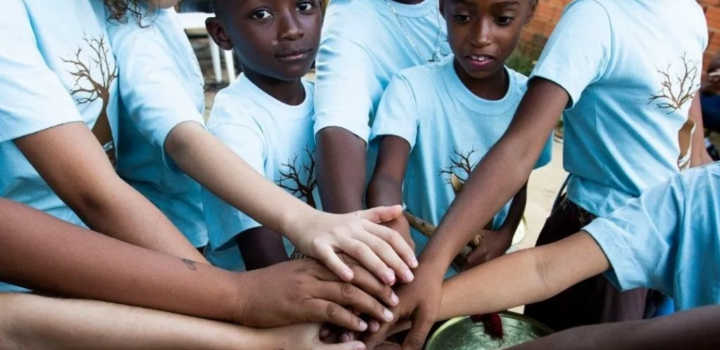 crianças com mãos umas sobres as outras