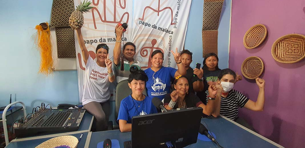 jornalistas indígenas com as mãos levantadas