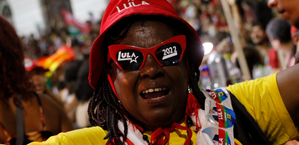 Mulher negra veste adereços com o nome Lula