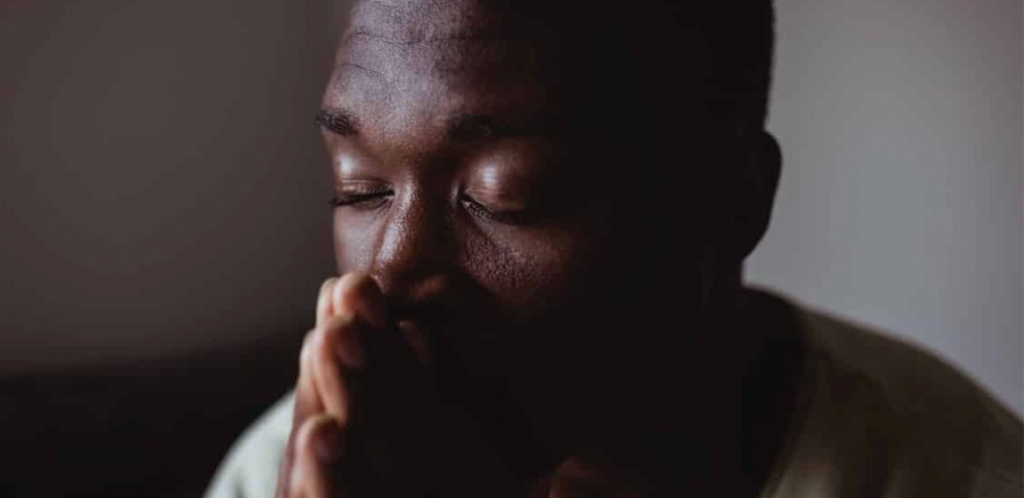 Foto mostra homem negro com a saúde mental abalada