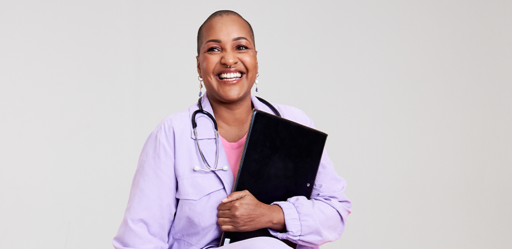 Foto mostra Luana sorrindo de jaleco branco e com um estetoscópio no pescoço