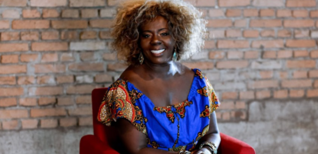 Mulher negra sentada em cadeira vermelha