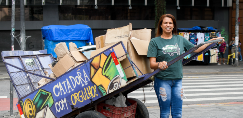 mulher segura carroça de lixo
