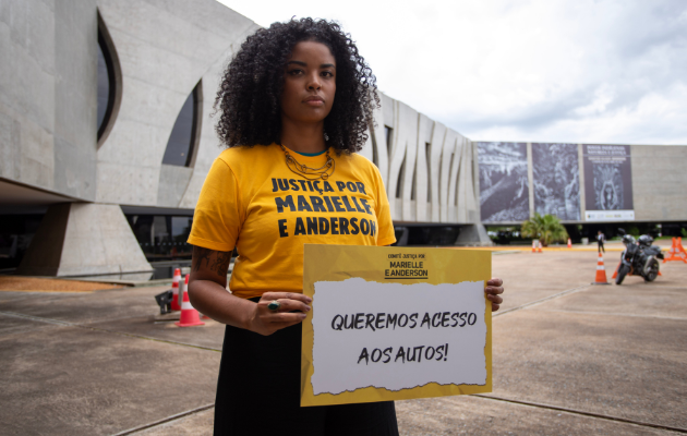 Foto mostra Lígia Batista, diretora-executiva do Instituto Marielle Franco, segurando a placa 