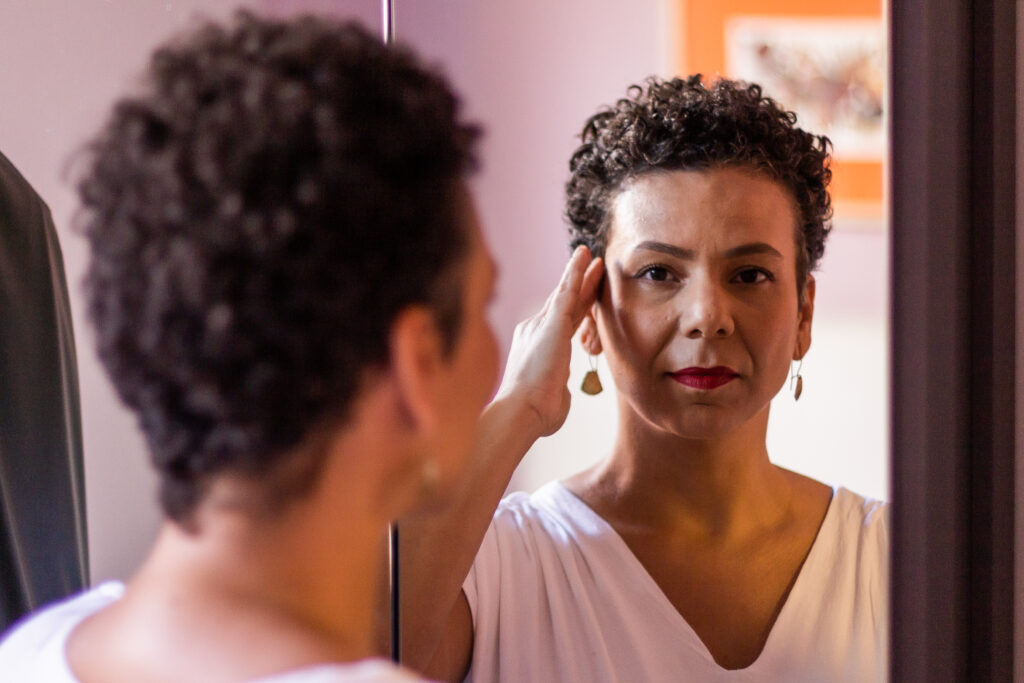 mulher se olha no espelho