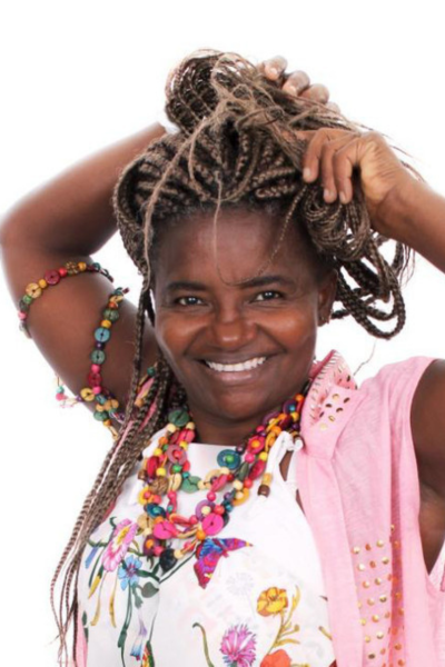 Imagem mostra Mc Dandara arrumando as tranças