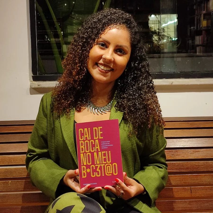 Foto mostra Tamiris Coutinho segurando seu livro 