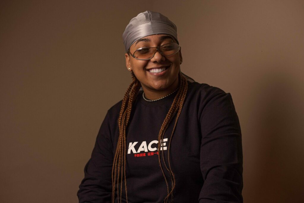 Iza Sabino, mulher negra de tranças sorrindo