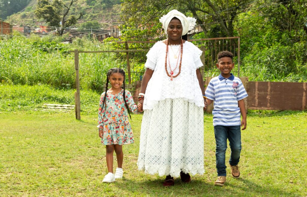 Mulher de mãos dadas com duas crianças