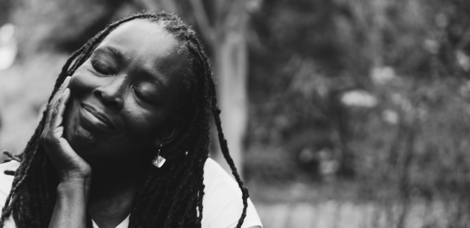 Foto mostra mulher negra de olhos fechados