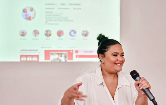 Foto mostra Rayane palestrando. Ao fundo, tela mostra instagram do Gorda na Lei