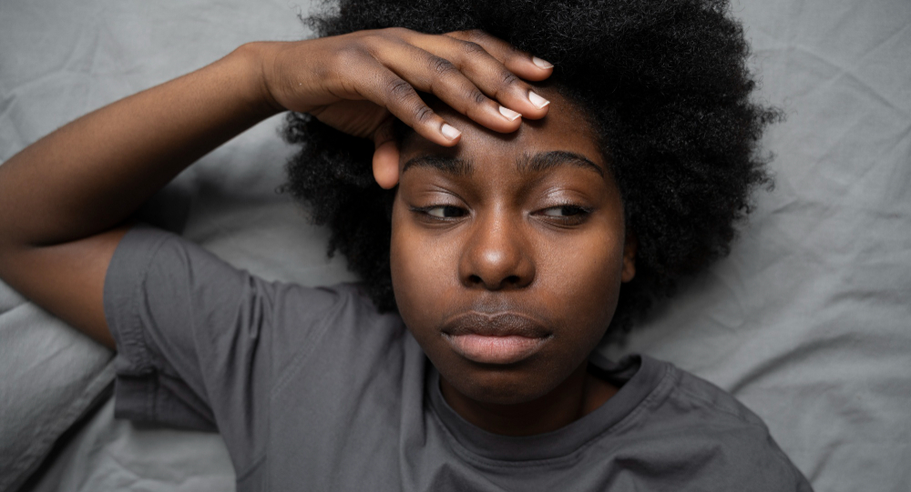 mulher deitada na cama com dor