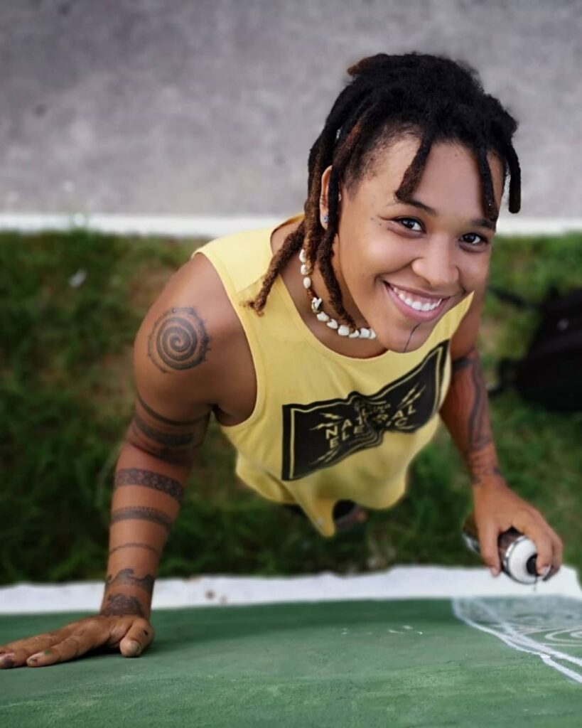 Foto mostra Ani, uma das grafiteiras, trabalhando