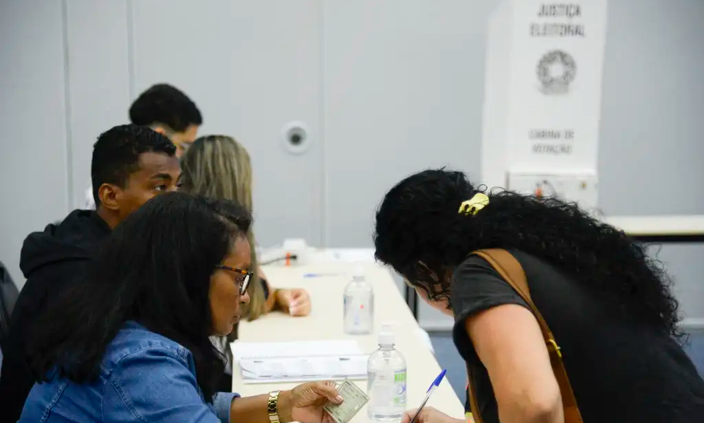 mulher assina papel em eleição