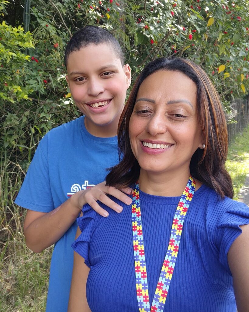 mãe e filho sorriem e vestem azul