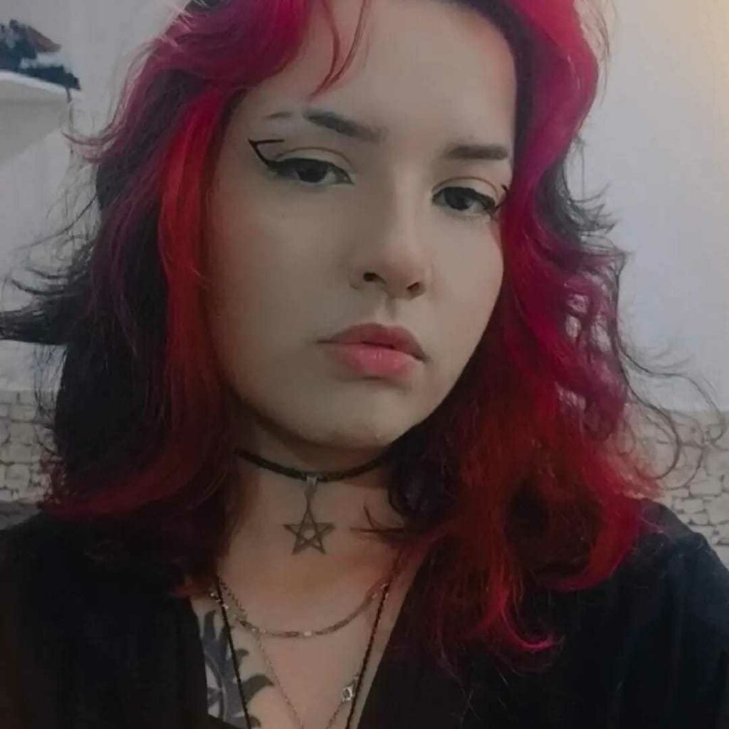 mulher branca com cabelo preto e mechas vermelhas