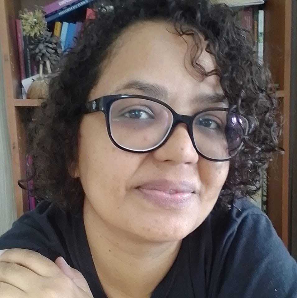 mulher negra de óculos e blusa preta