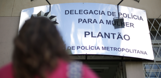 Foto mostra mulher entrando em delegacia da mulher, em alusão à Lei do Feminicídio