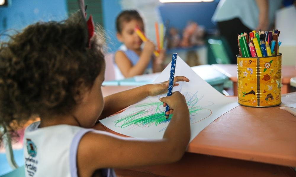 Foto mostra crianças desenhando com lápis de cor em uma das creches brasileiras