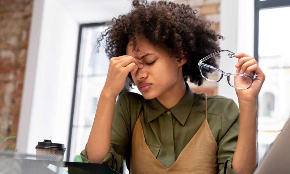 Foto mostra mulher com cara preocupada por conta de dívida