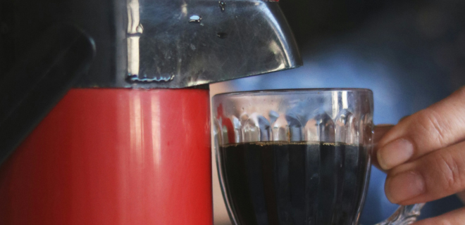 Foto mostra garrafa e xícara de café