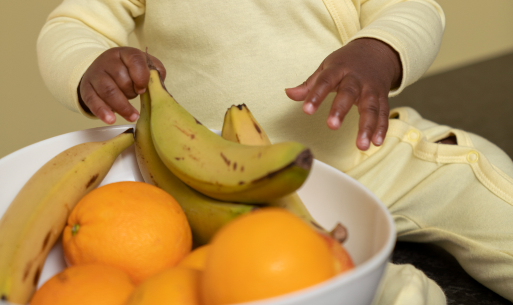 mão de criança e frutas