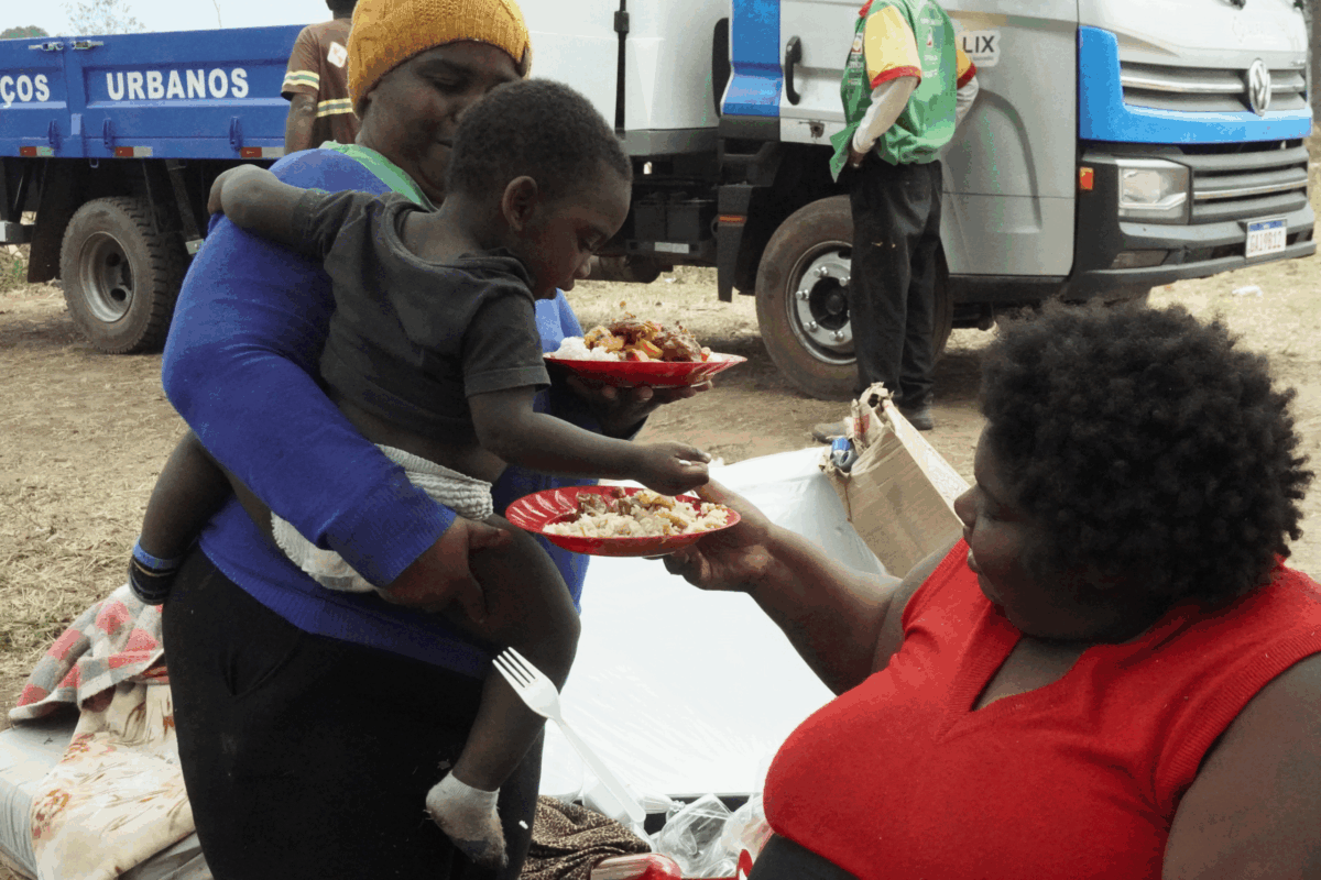 Duas mulheres e uma criança com um prato de comida