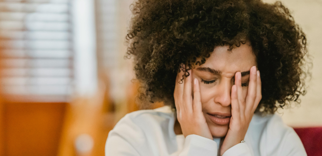 Foto mostra mulher negra com a saúde mental abalada chorando