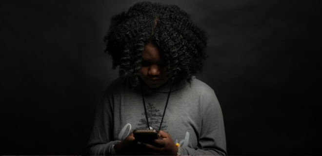 Foto mostra mulher negra mexendo na internet pelo celular