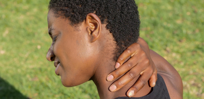 Foto mostra mulher negra com dor no pescoço